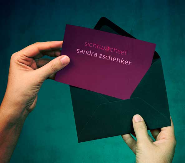 Hand die einen Briefumschlag hält, auf der Karte das Logo und der Name Sandra Zschenker